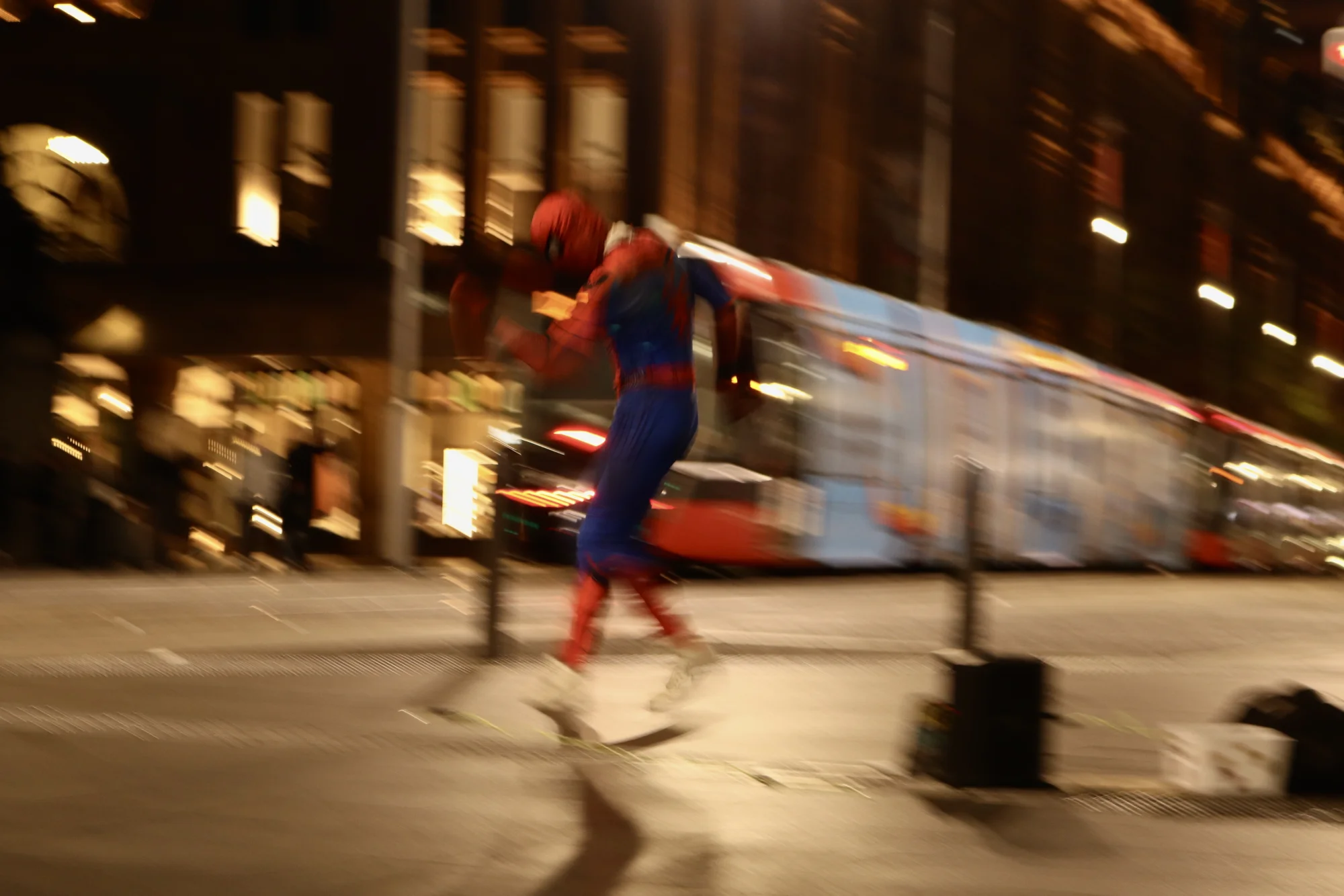 Spider-Man dancing beside a tram in Sydney's Chinatown at night